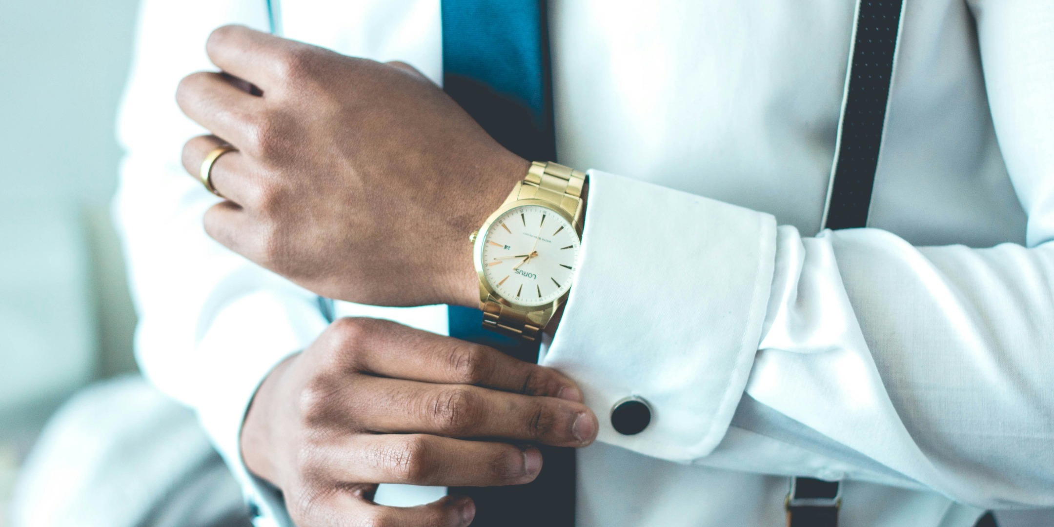 Stilig man i kostym med guldklocka